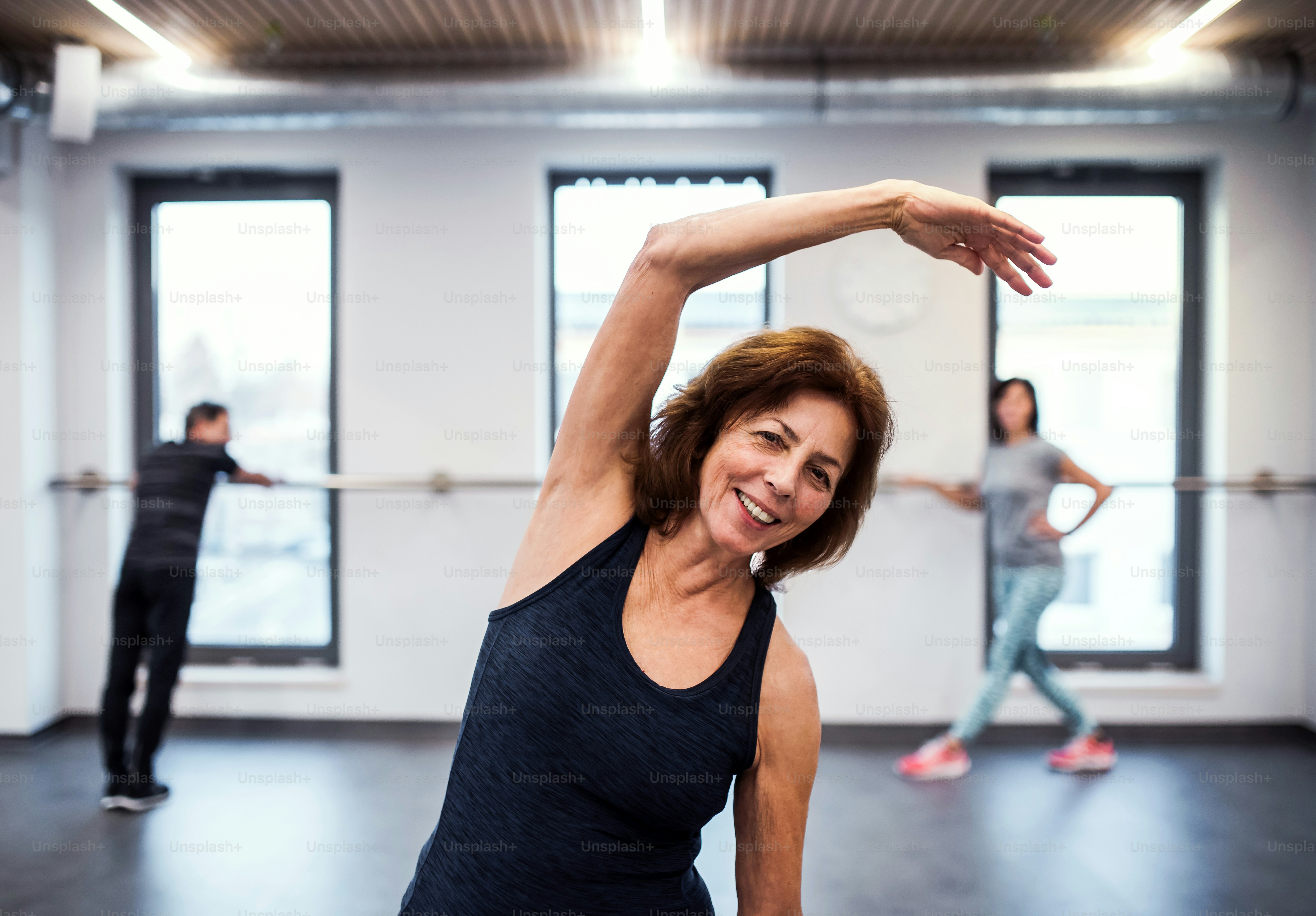 Una alegre mujer mayor en el gimnasio haciendo ejercicio. Espacio de copia.