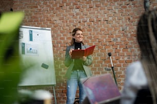 A young businesswoman standing and having a presentation in office, cooperation concept.