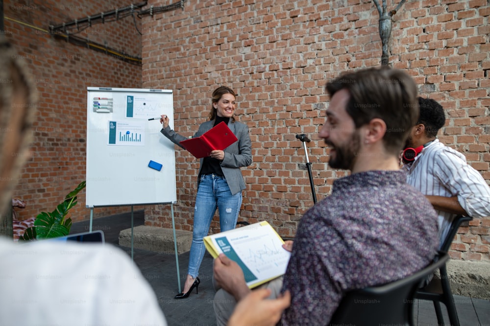 Young businesspeople standing and working in office, cooperation, presentation and a brainstorming concept.