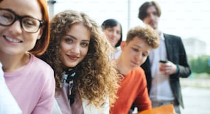 A portrait of businesspeople entrepreneurs outdoors indoors in office, looking at camera.