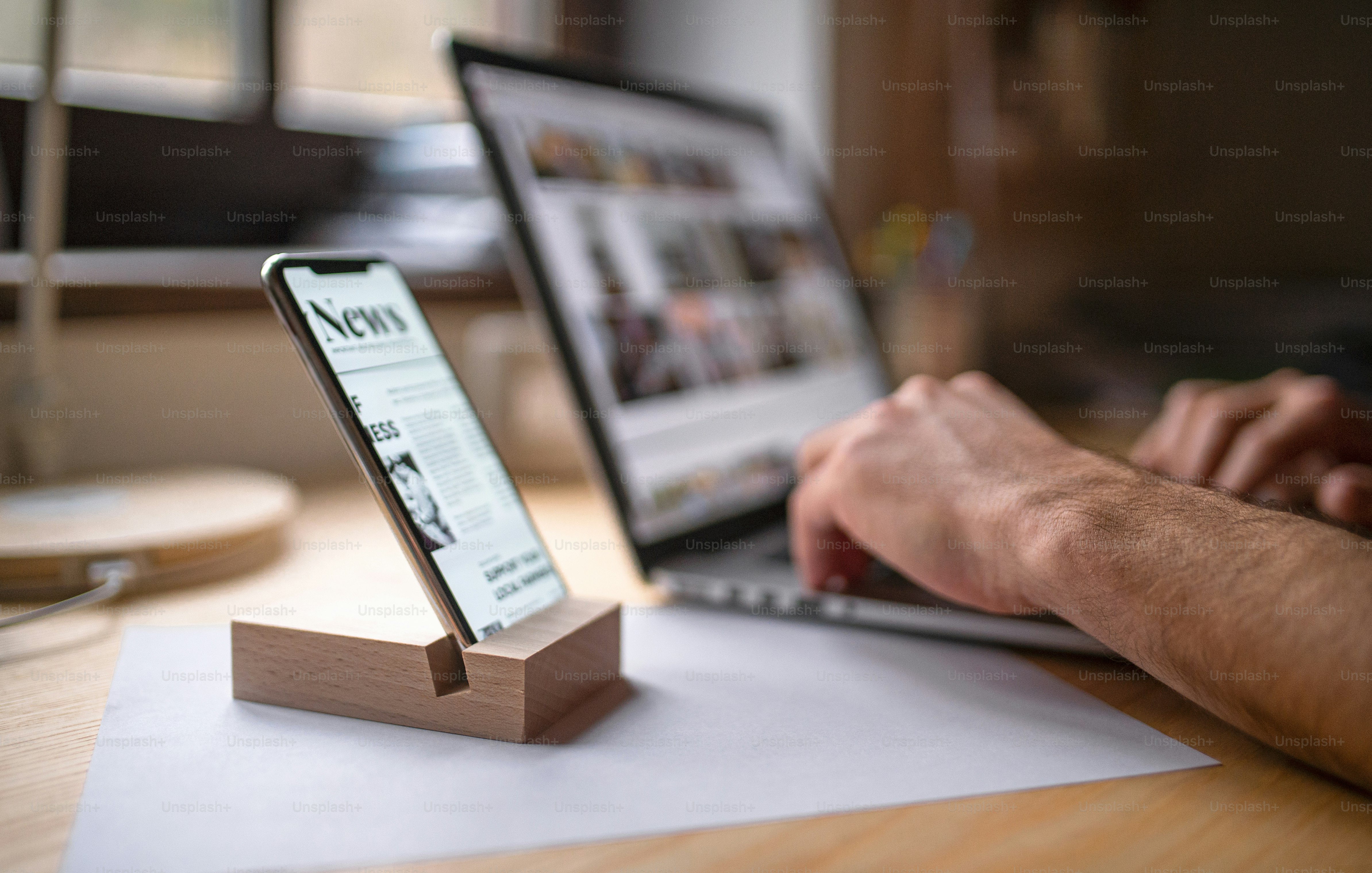 A smartphone in wooden stand holder on table indoors at home or on ...