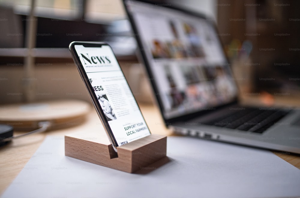 Un teléfono inteligente en soporte de madera en la mesa en el interior de casa o en la oficina.
