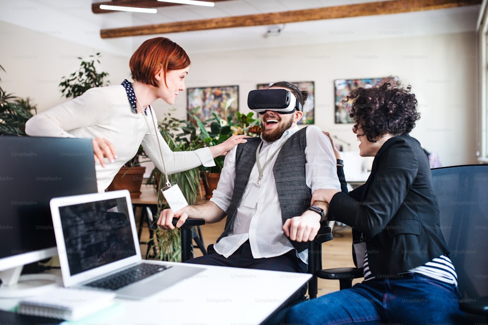 Eine Gruppe junger Geschäftsleute mit VR-Brille, die sich im Büro unterhalten, Start-up-Konzept.