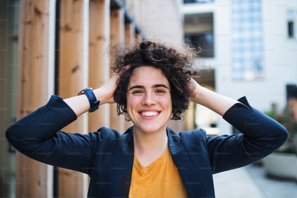 A happy young business woman standing outdoors, resting. Start-up concept.