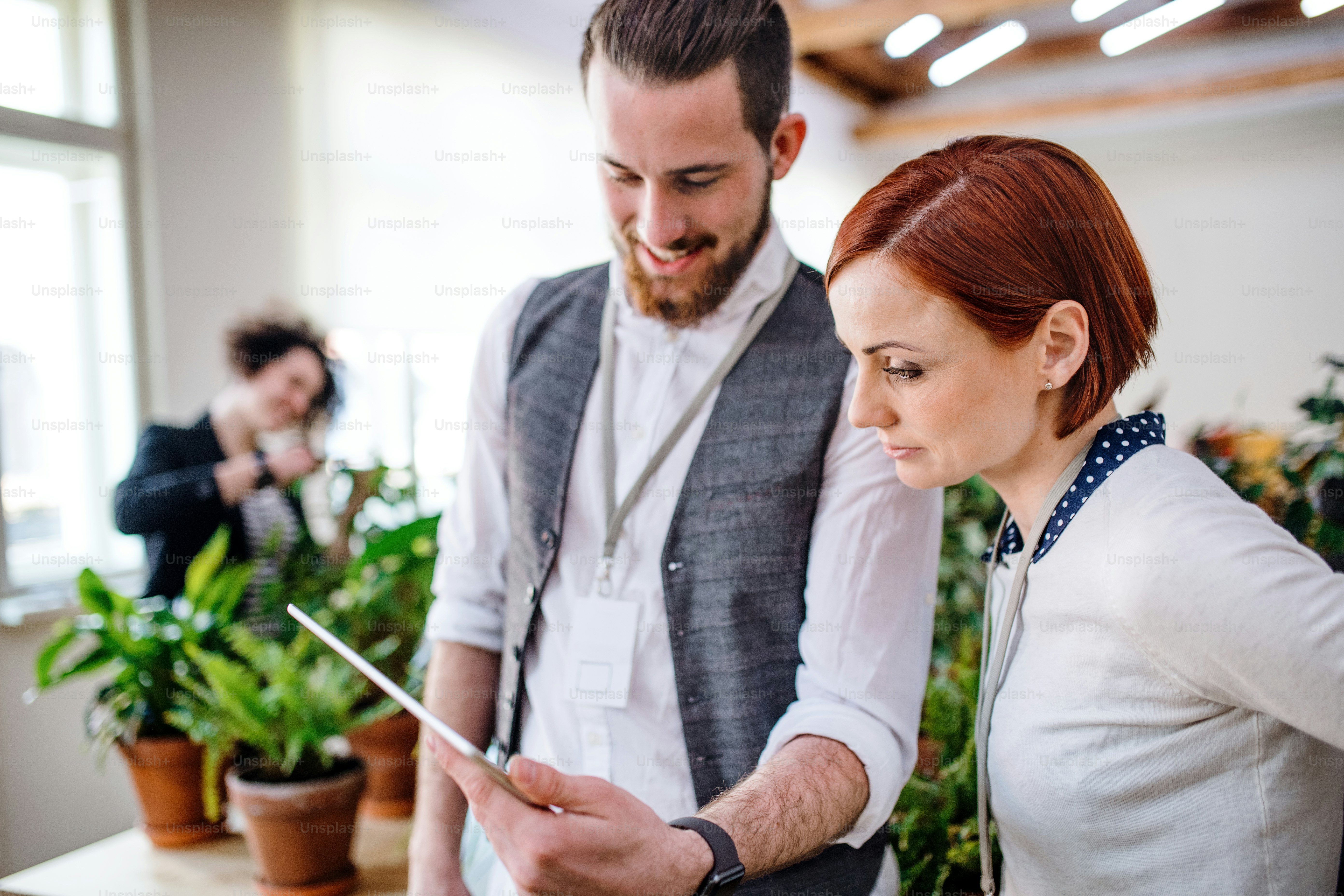 Two young businesspeople using a tablet in office, start-up concept.