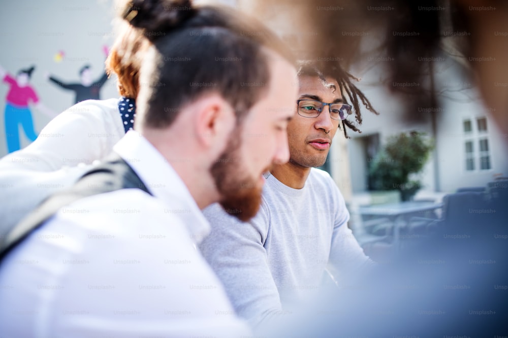 Un primer plano de jóvenes empresarios en el patio, hablando. Un concepto de start-up.