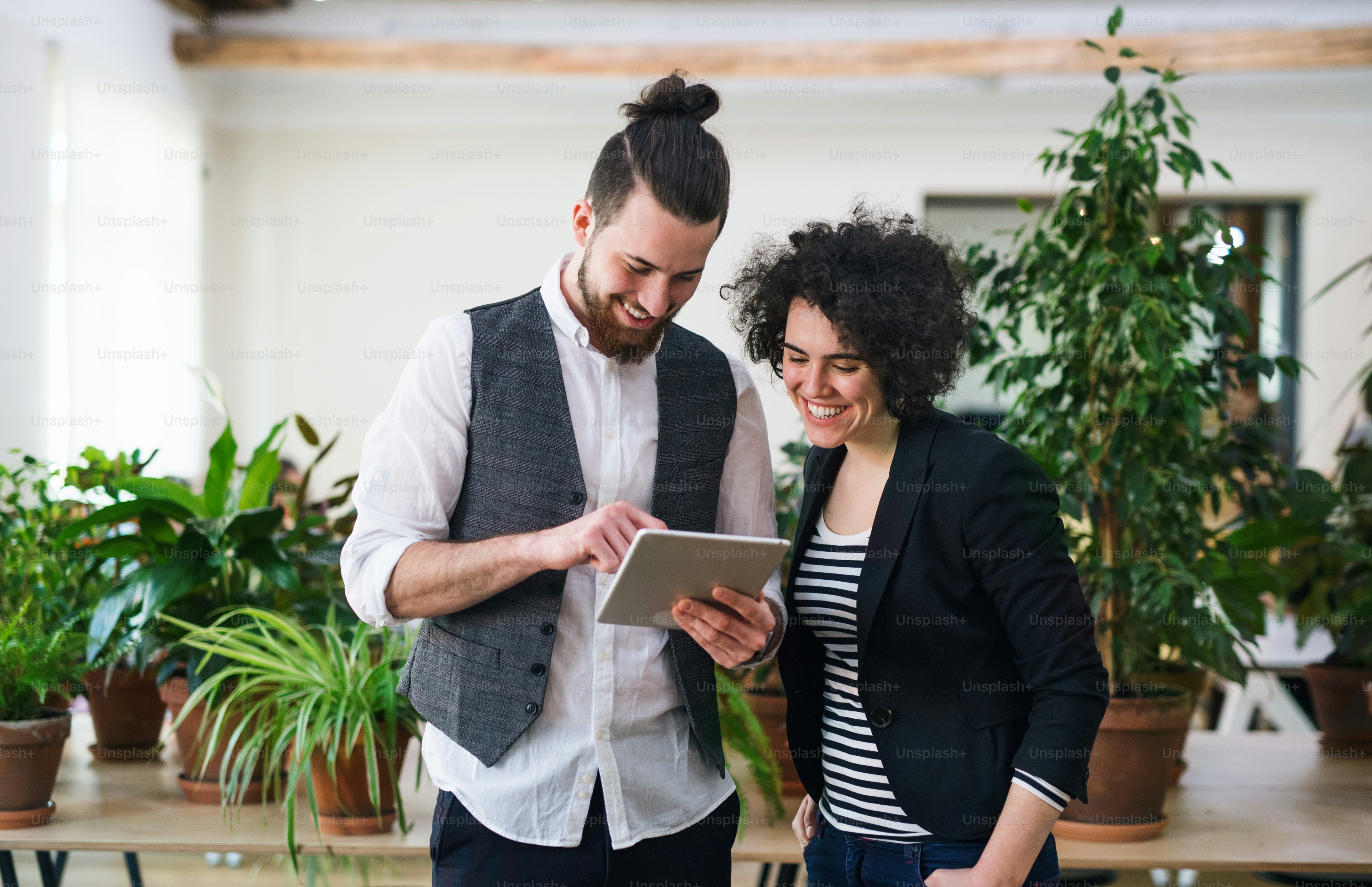 Dois jovens empresários usando um tablet no escritório, conceito de start-up
