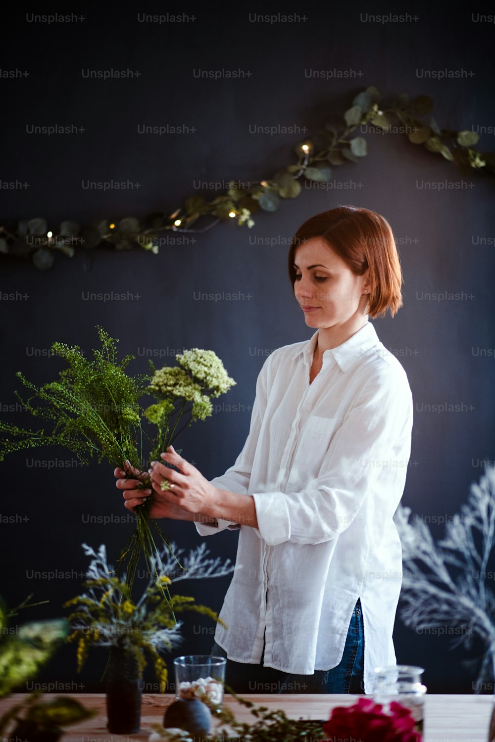Una giovane donna creativa che organizza fiori in un negozio di fiori. Una startup di attività di fiorista.