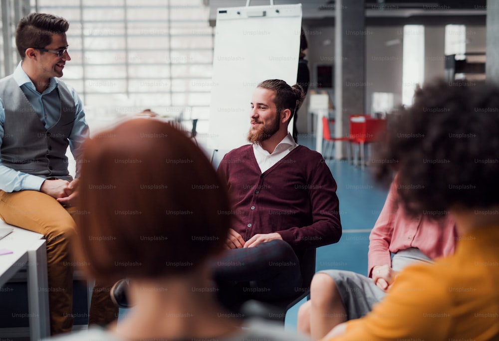 A group of young businesspeople working together in office, talking.