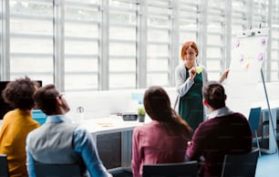 A group of young businesspeople in office, listening to a presentation.