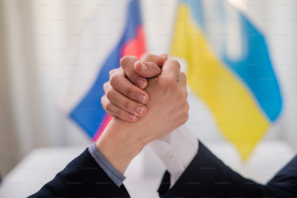 Os representantes da Ucrânia e da Rússia apertando as mãos, conceito de acordo de paz da Ucrânia.
