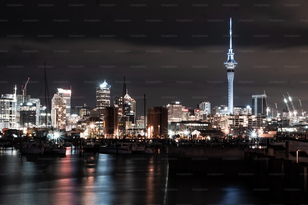 Una vista nocturna de una ciudad con una torre muy alta