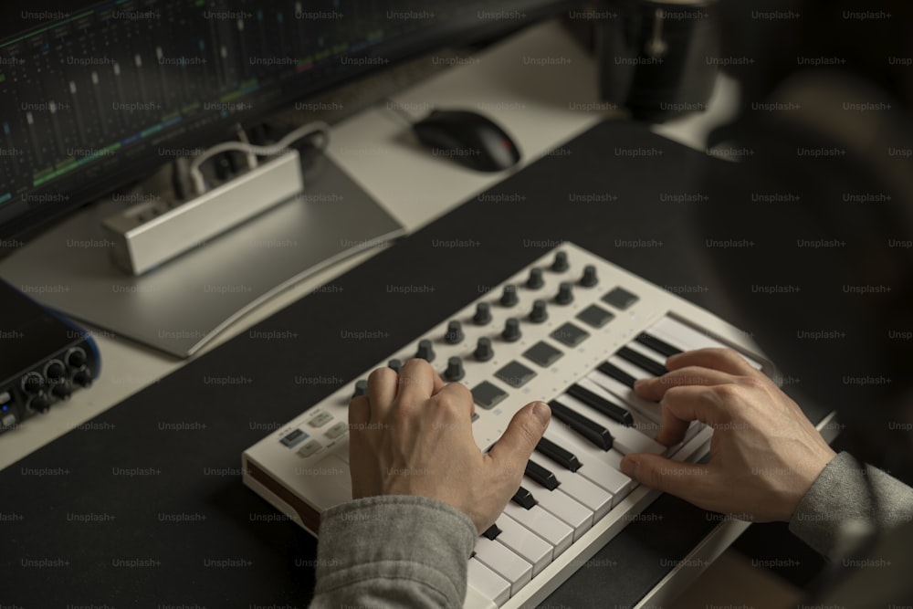 a person is working on a keyboard in front of a computer