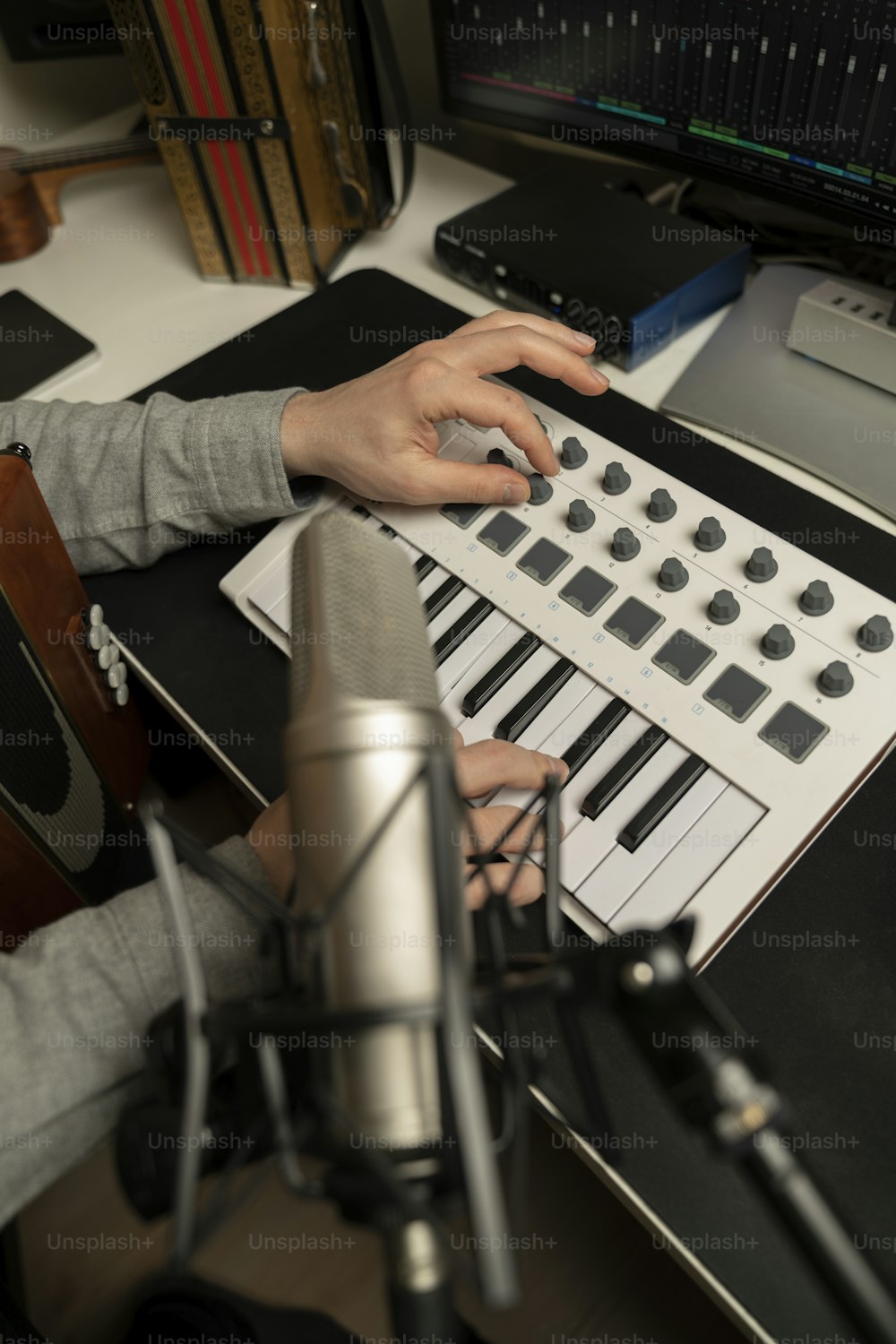 a person sitting in front of a microphone playing a keyboard