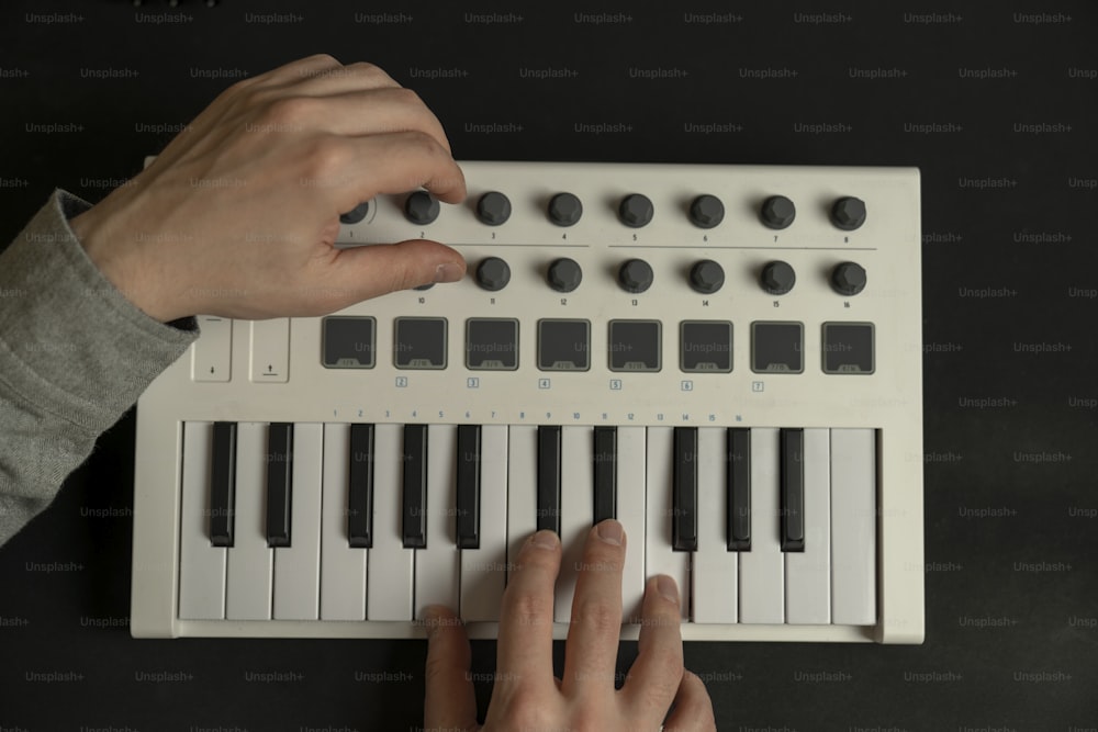 a person playing a keyboard with their hands