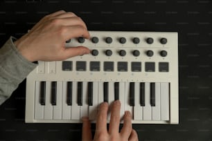 uma pessoa tocando um teclado com as mãos