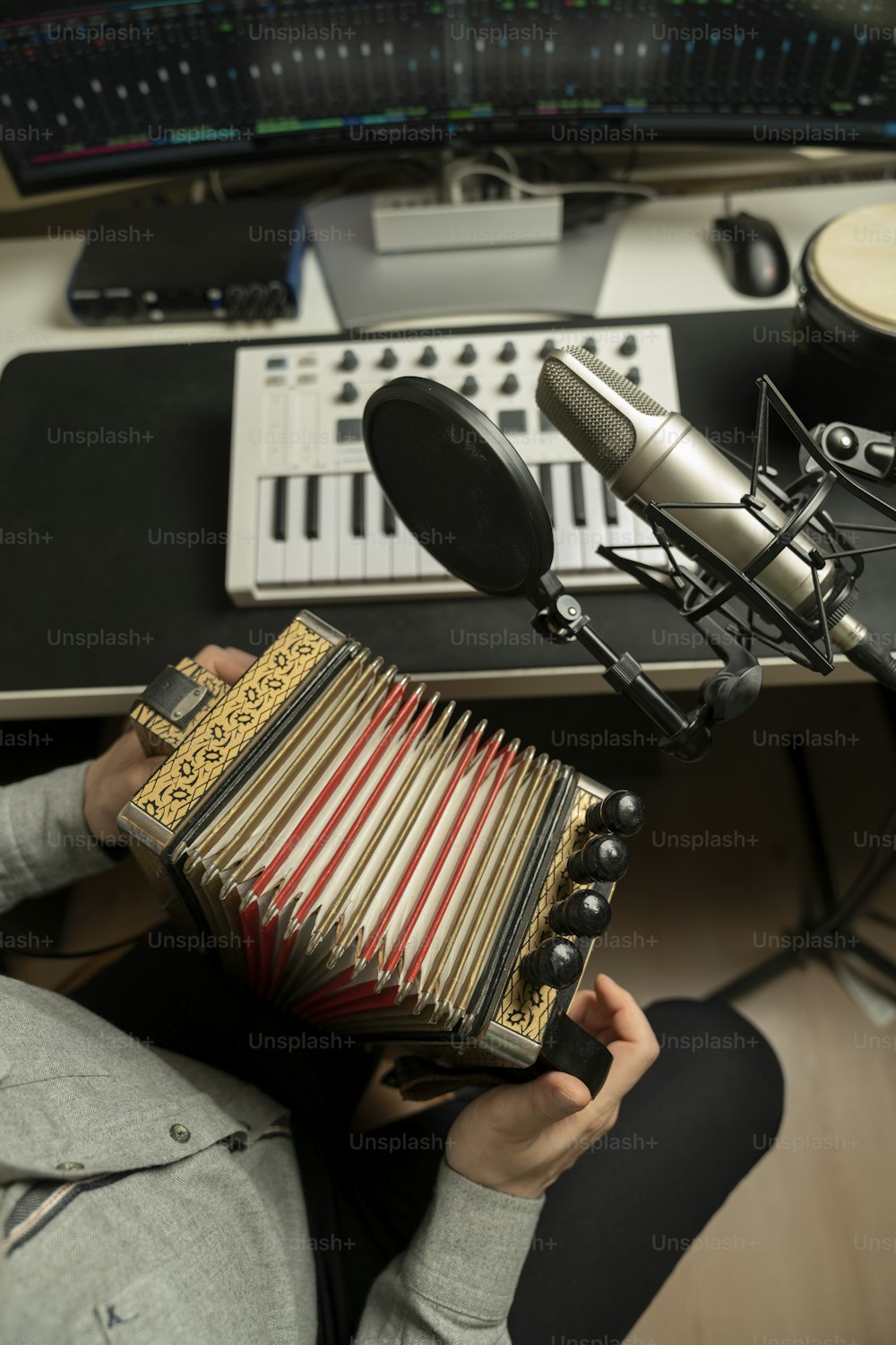 une personne tenant un accordéon devant un microphone