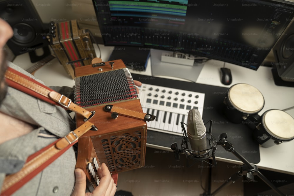 a man sitting in front of a computer with a microphone