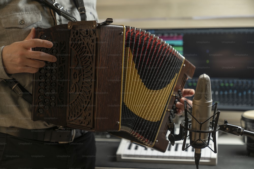 a man holding an accordion in front of a microphone