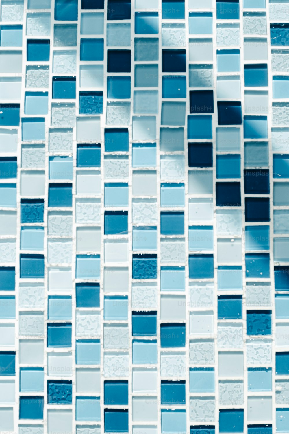 a close up of a blue and white mosaic tile wall