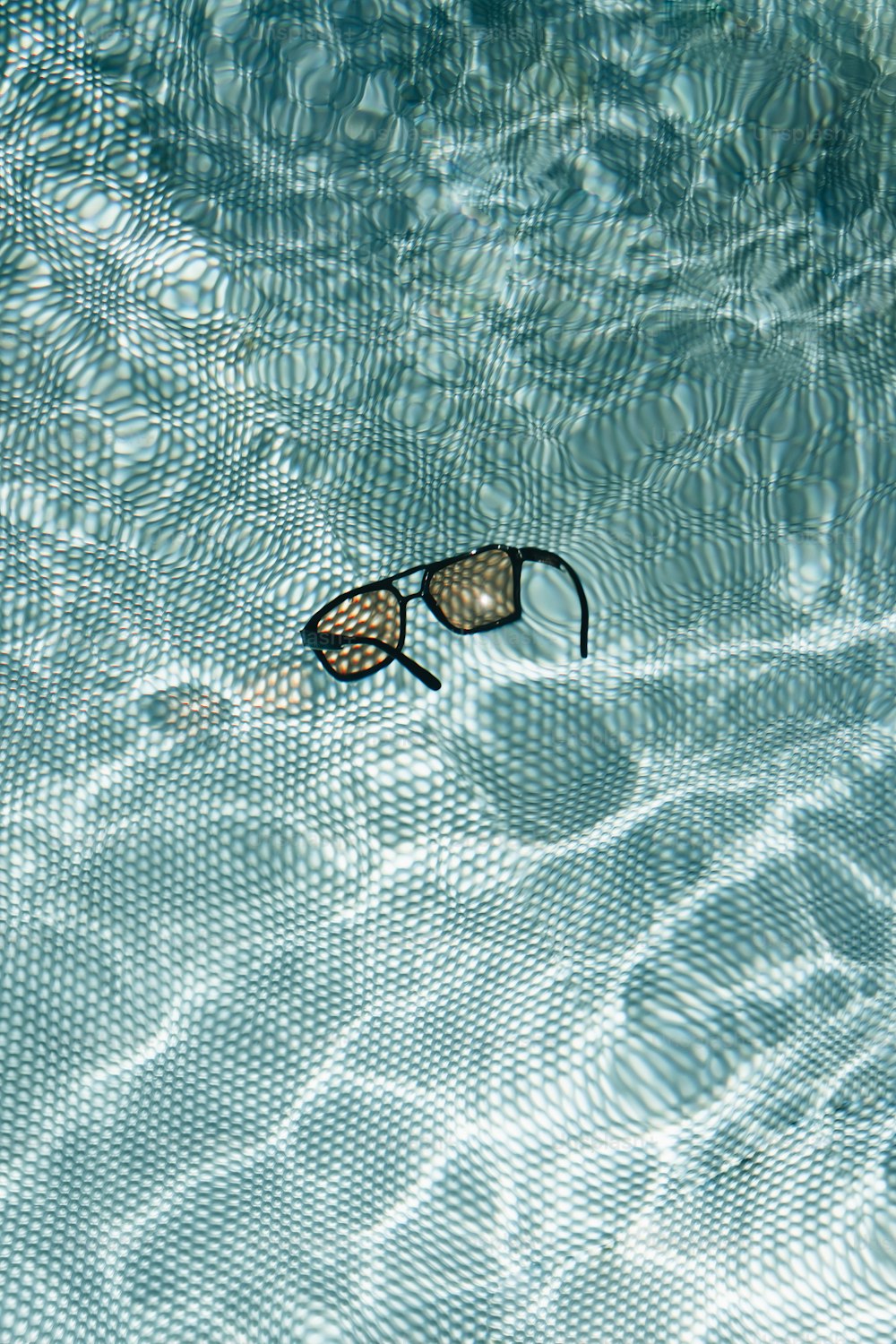 um par de óculos de natação flutuando em uma piscina