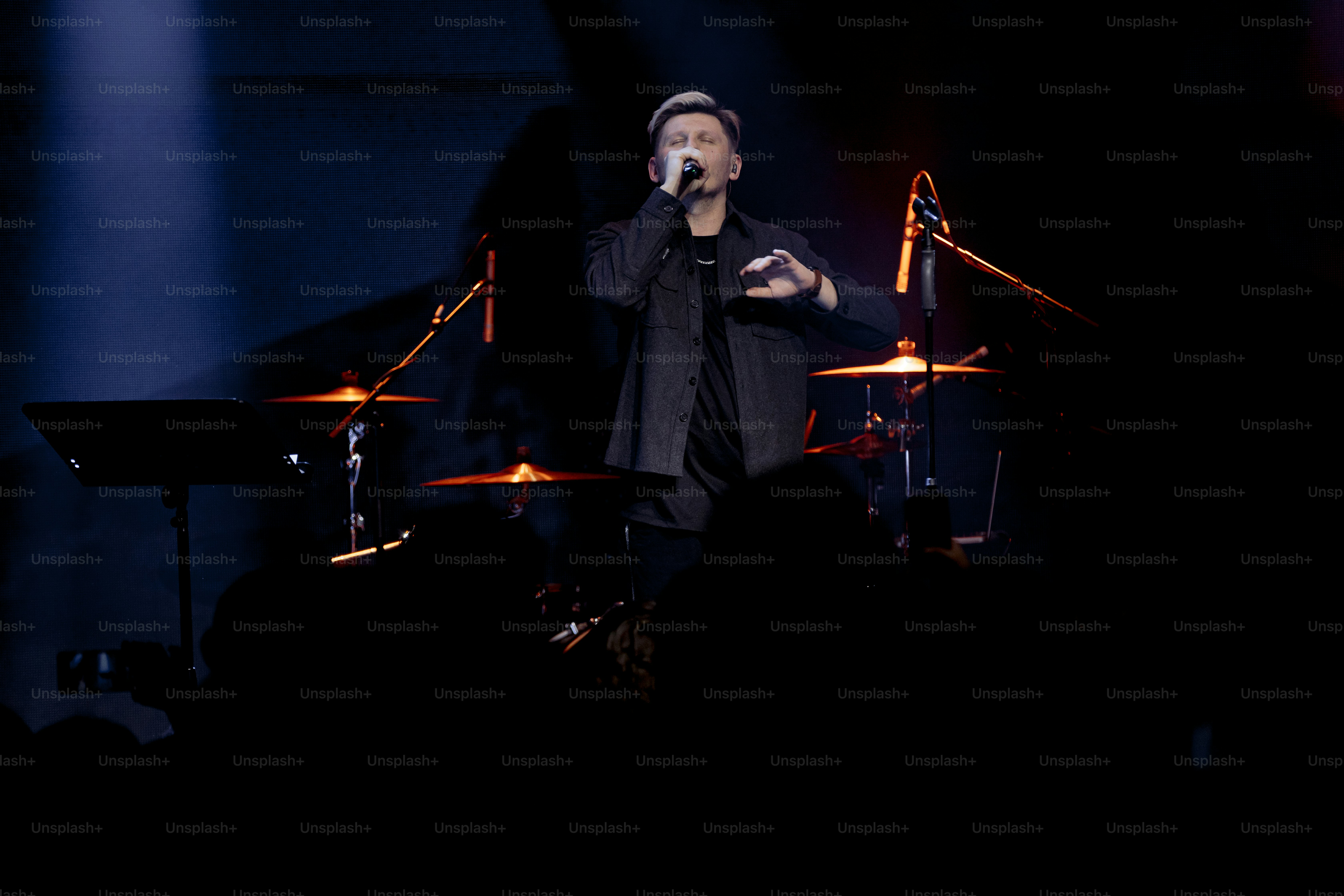 a man standing on top of a stage holding a microphone