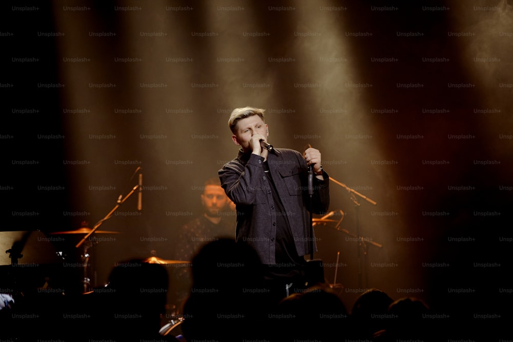 a man standing on a stage holding a microphone