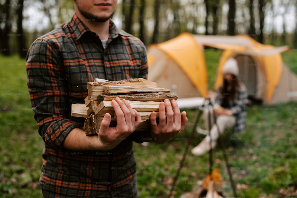 um homem segurando um livro na frente de uma tenda