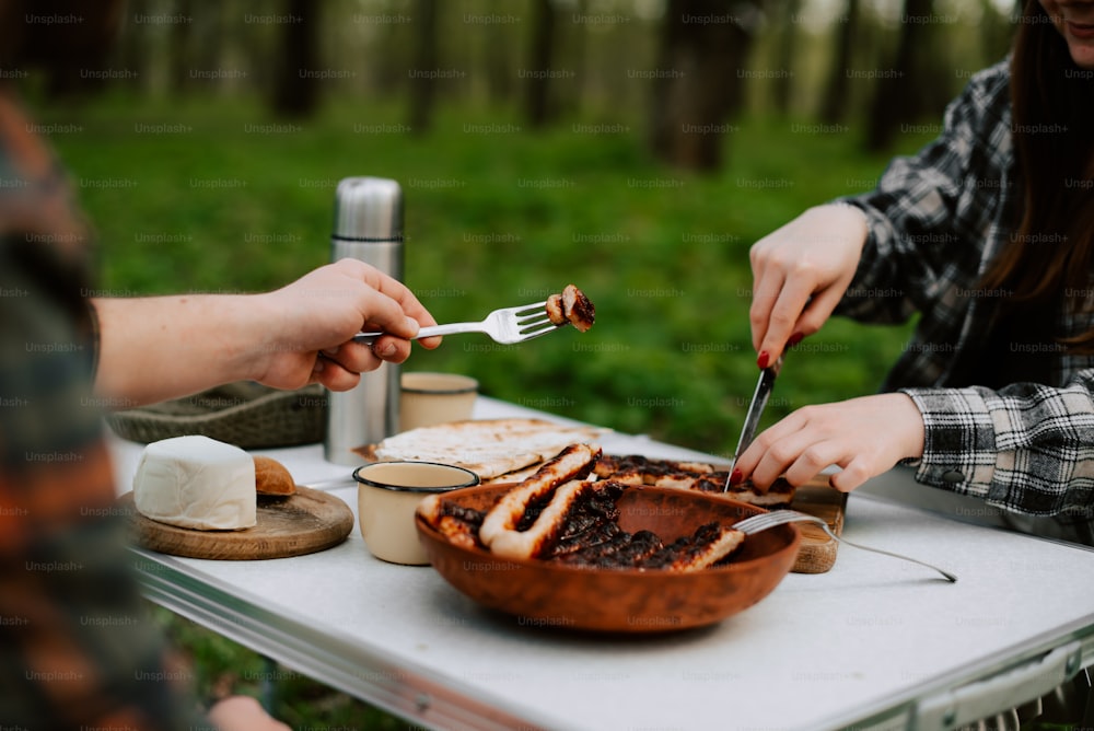 Un par de personas sentadas en una mesa con comida