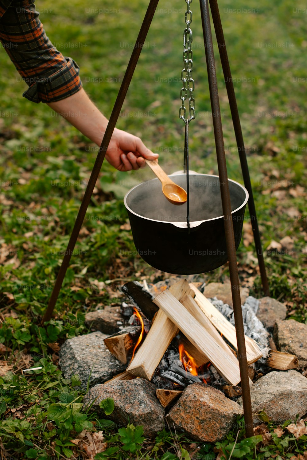 모닥불 위에서 음식을 요리하는 사람