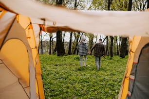 a couple of people walking through a forest