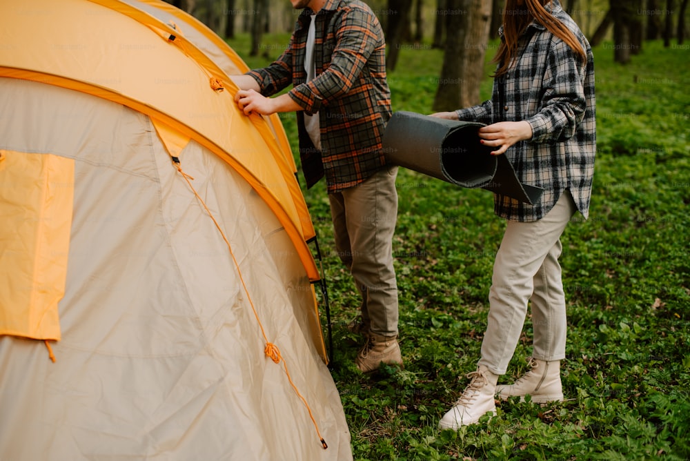 um par de pessoas de pé ao lado de uma tenda