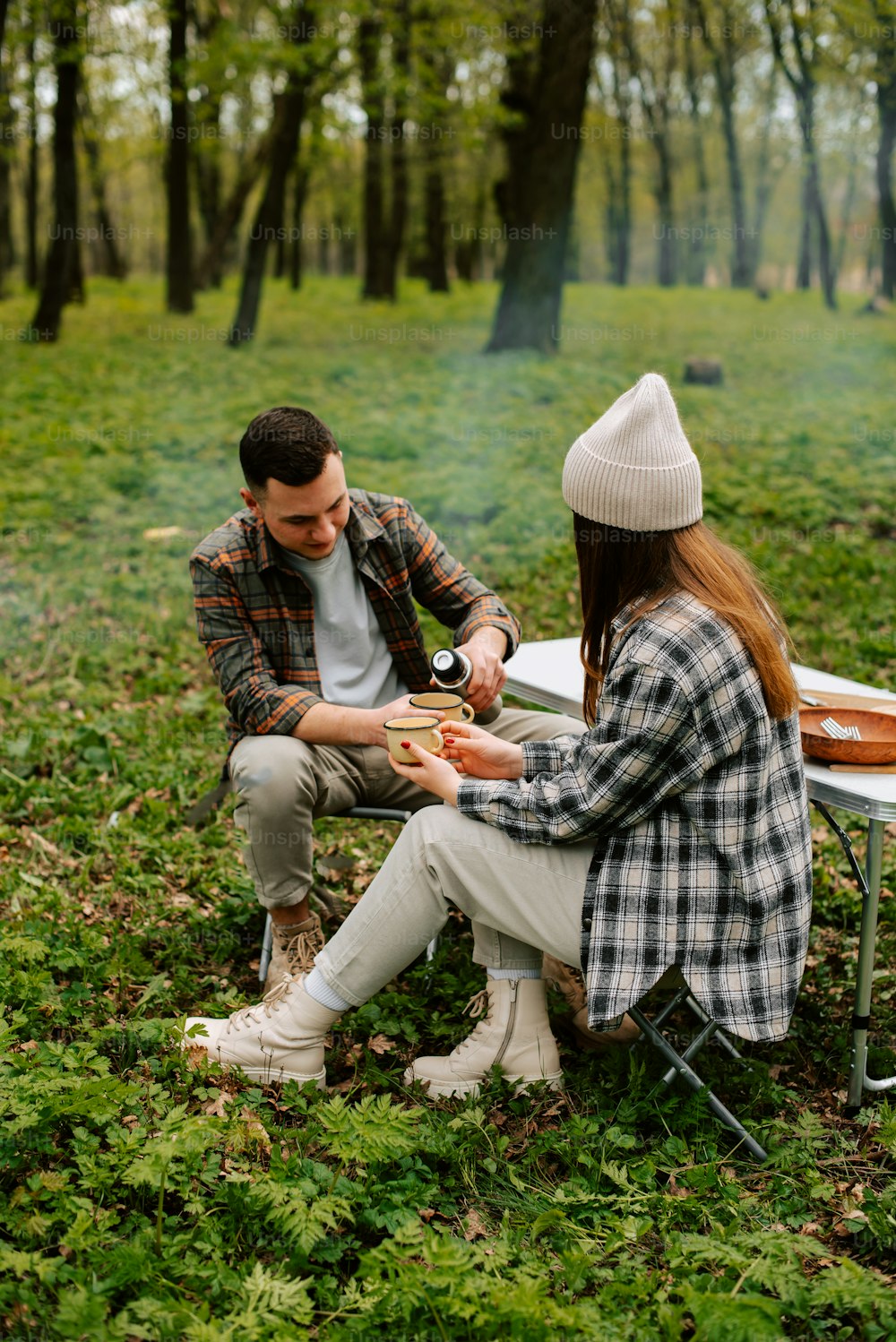 um homem e uma mulher sentados em um banco na floresta