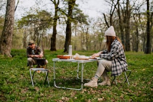two people sitting at a table in the woods