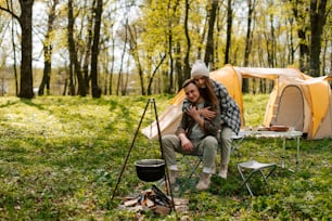 a man and a woman sitting in front of a tent