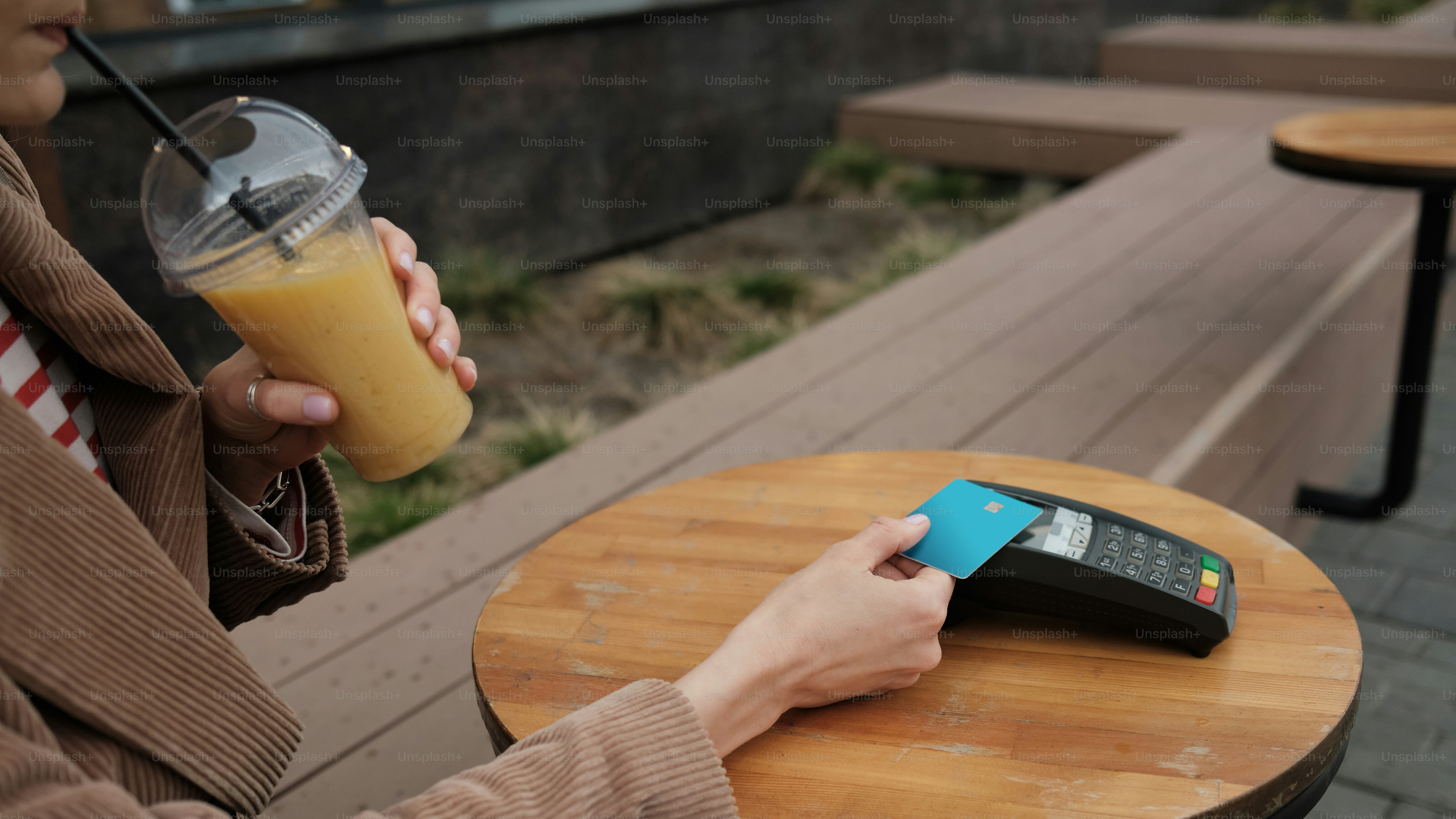 eine Person, die ein Getränk und ein Handy in der Hand hält