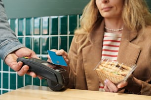 a woman paying a man a credit card