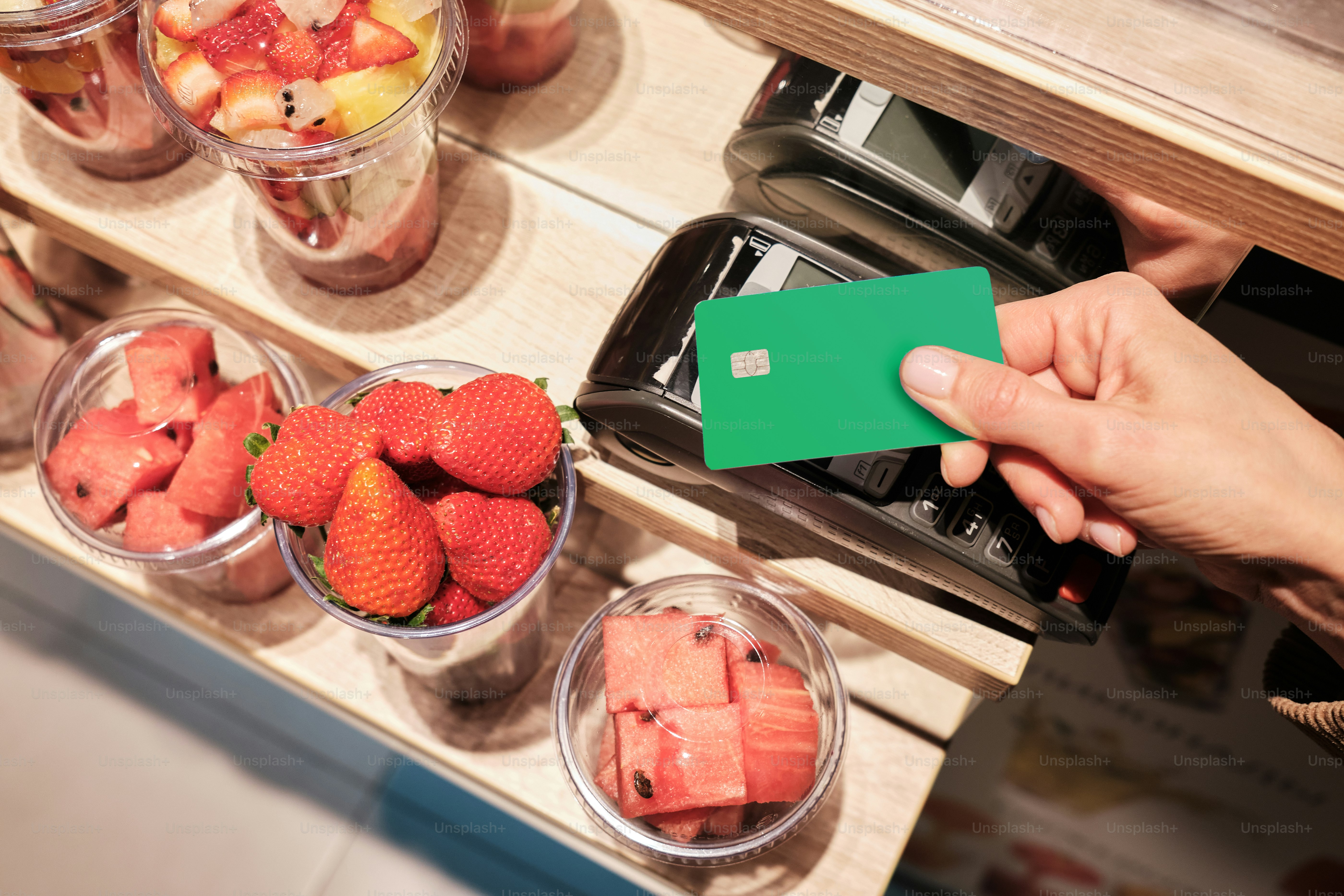eine Person, die eine grüne Karte vor einem Obst hält