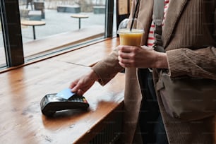 a person holding a drink and a cell phone