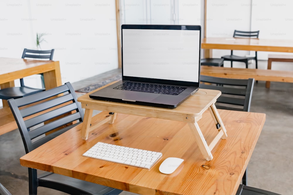 um computador portátil sentado em cima de uma mesa de madeira