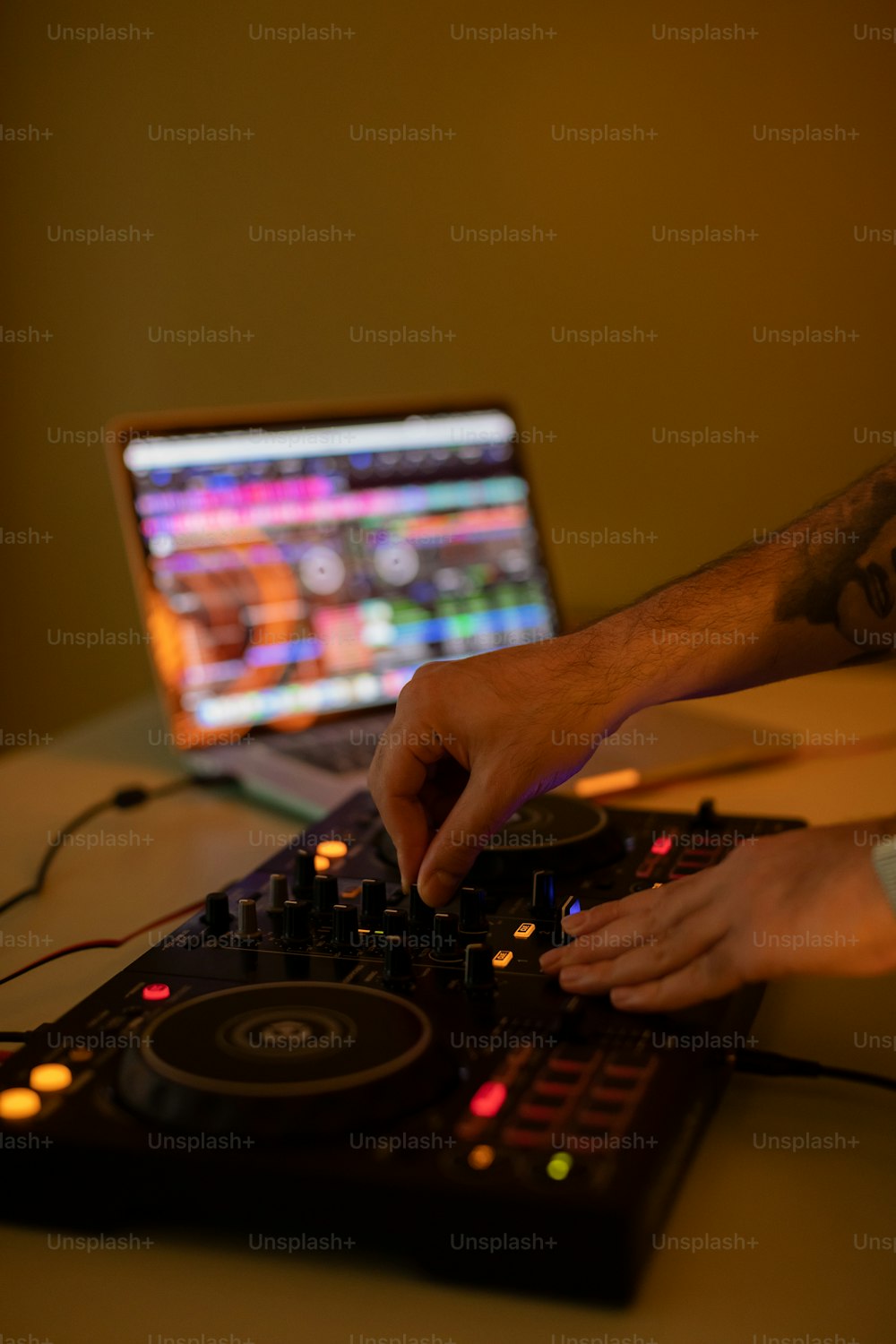 노트북 컴퓨터에서 음악을 믹싱하는 DJ