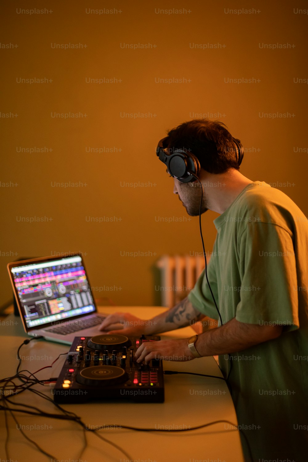 a man wearing headphones is using a laptop