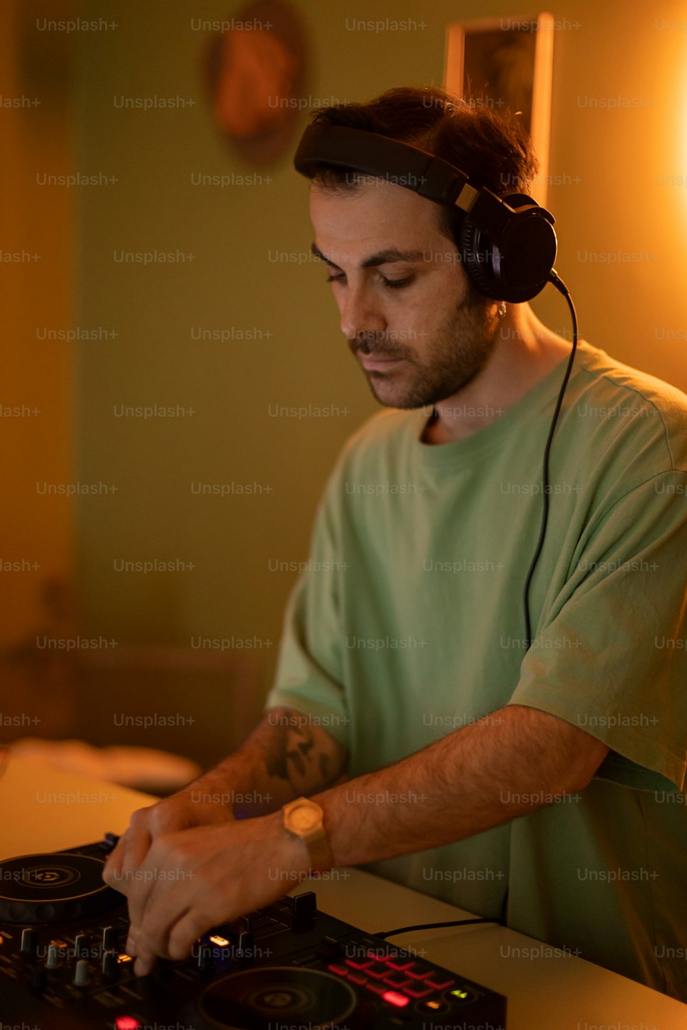 Ein Mann mit Kopfhörern spielt auf dem Plattenspieler eines DJs