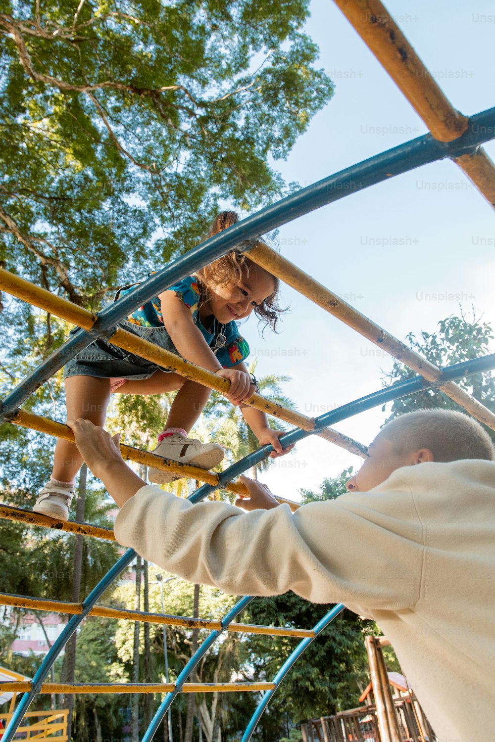 a man holding a little girl on top of a slide