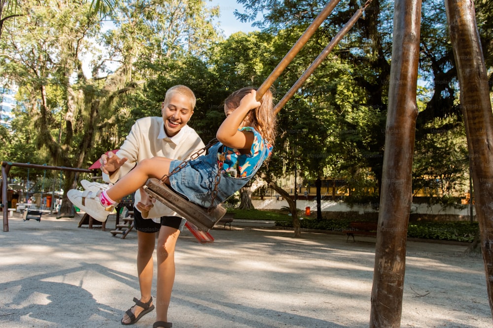 a man and a little girl playing on a swing