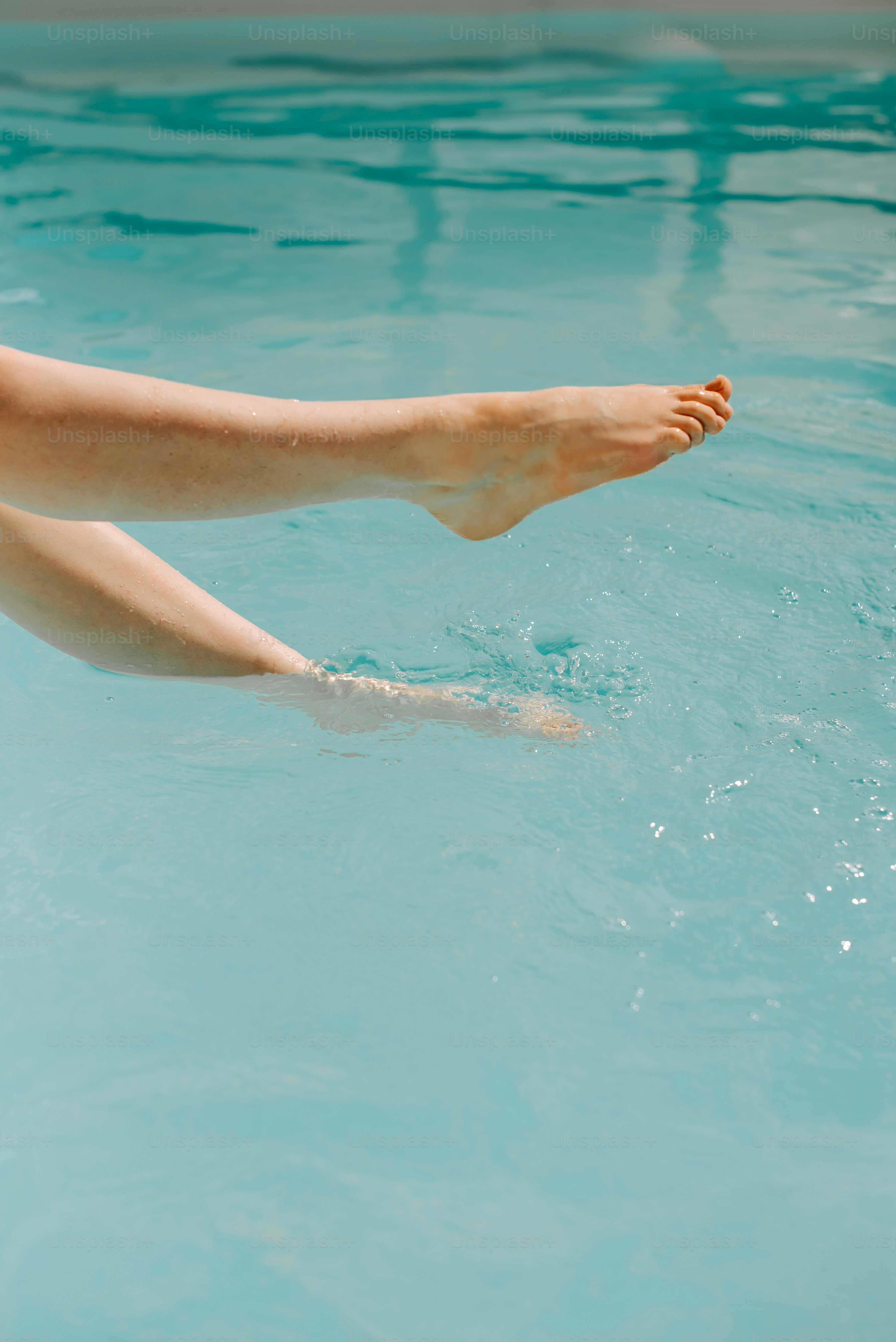 a woman's bare feet floating in a pool of water