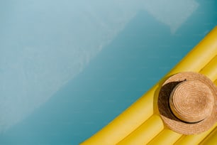 a straw hat sitting on top of a yellow tube