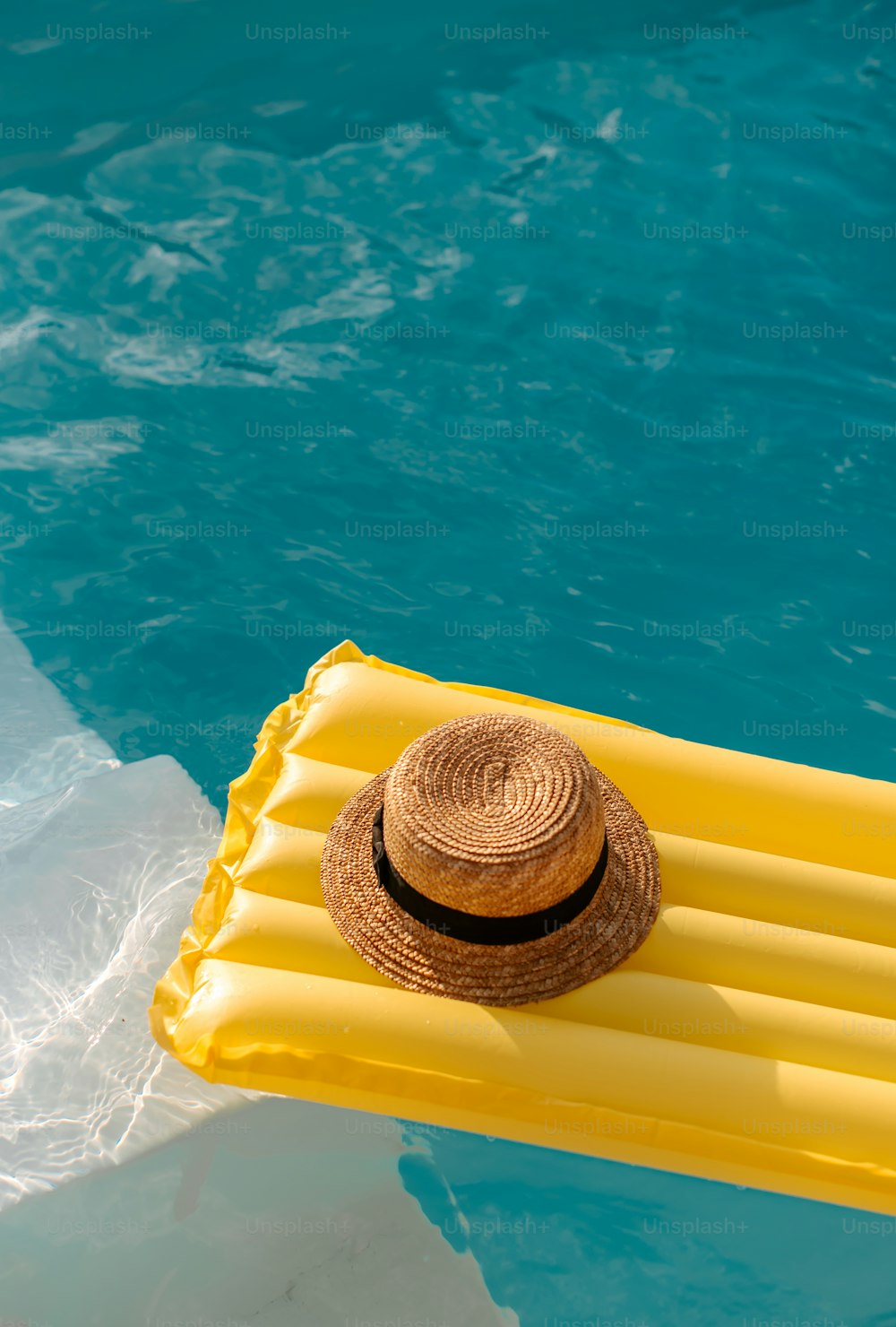 a straw hat on a raft floating in a pool