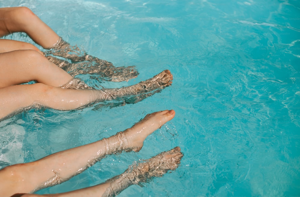 수영장에 발을 담그고 앉아 있는 두 여자