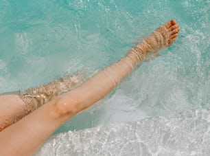 a woman laying in the water with her feet in the water